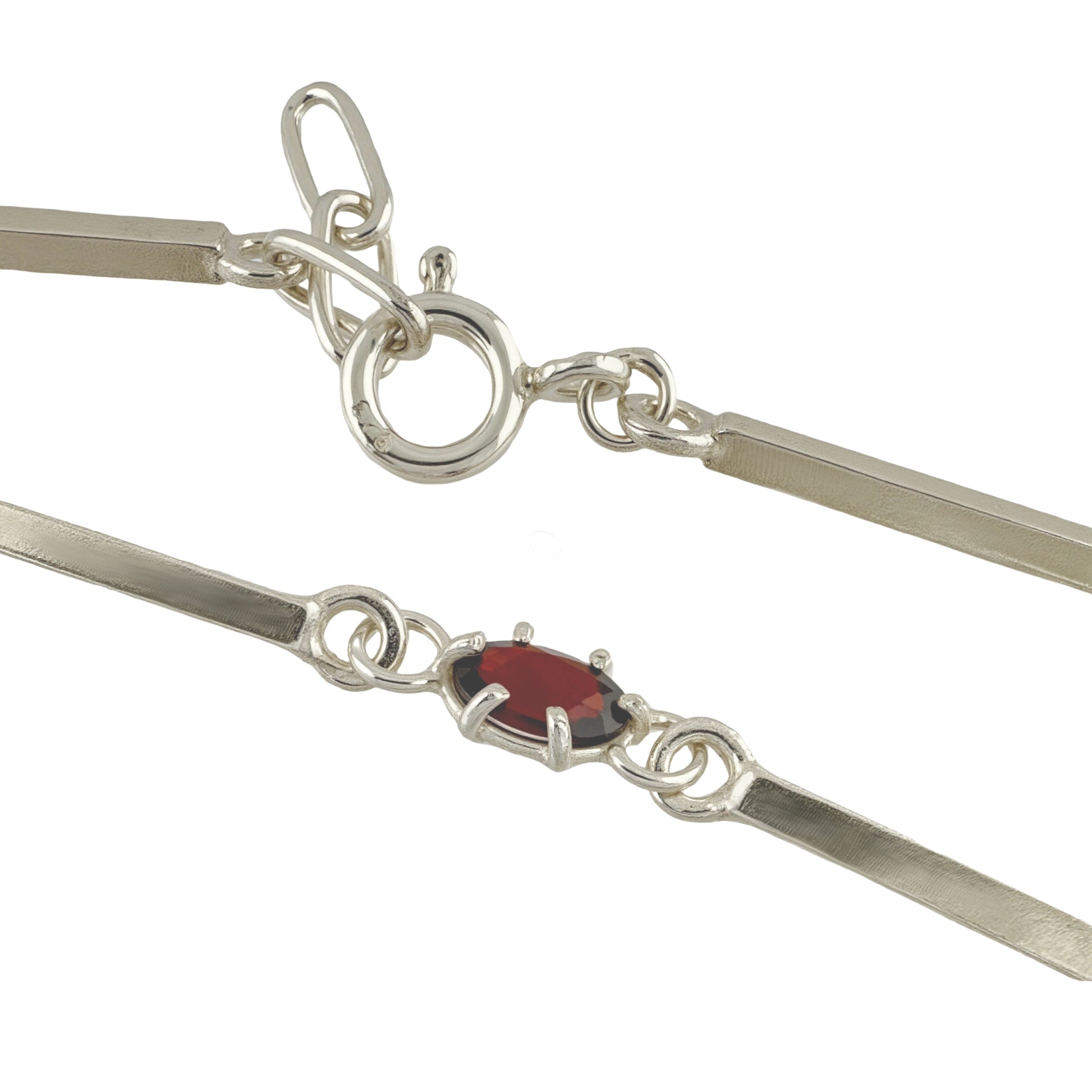 Close-up to a silver bracelet lock with a red gemstone on a white background