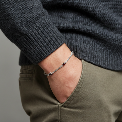 a man holding his hand in the pocket but you can see a bracelet with deep red zirconias on his wrist