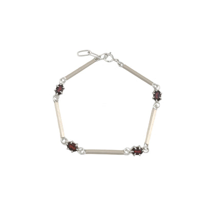 Silver bracelet with red gemstones on a white background