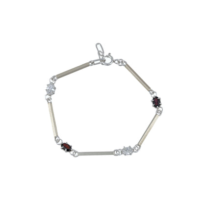 Silver bracelet with white and red gemstones on a white background