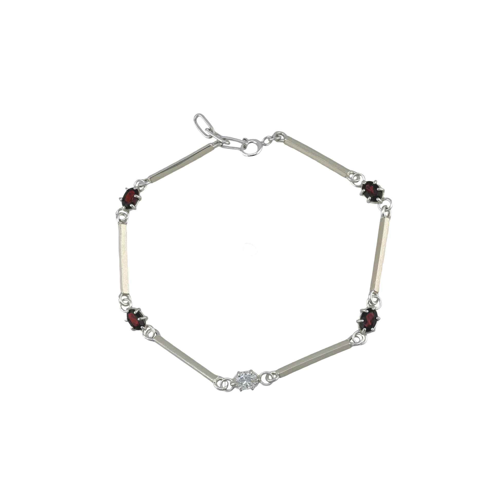 Silver bracelet with red and white gemstones on a white background