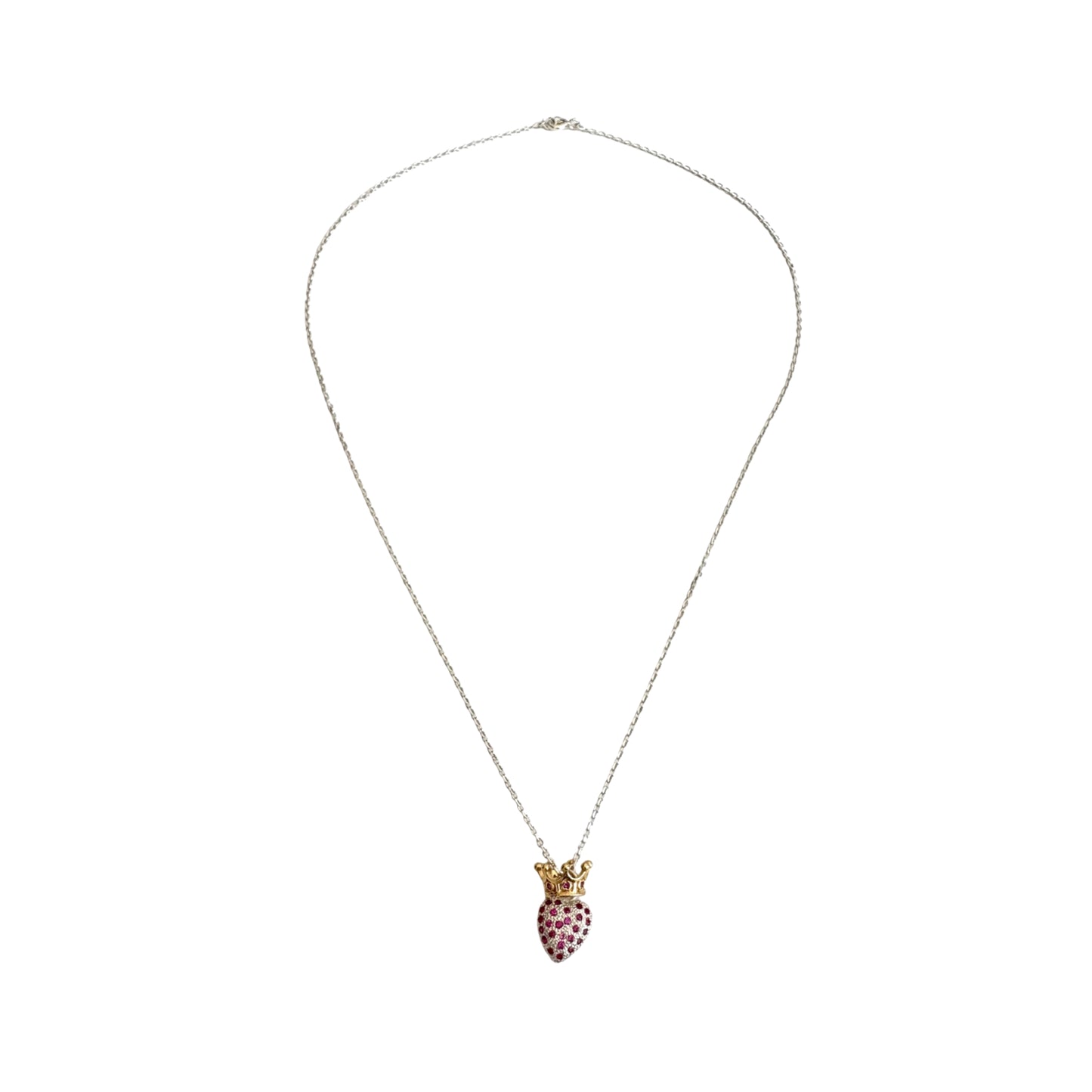 A long silver chain with a heart shaped pendant encrusted with red zirconias and topped with a gold crown.