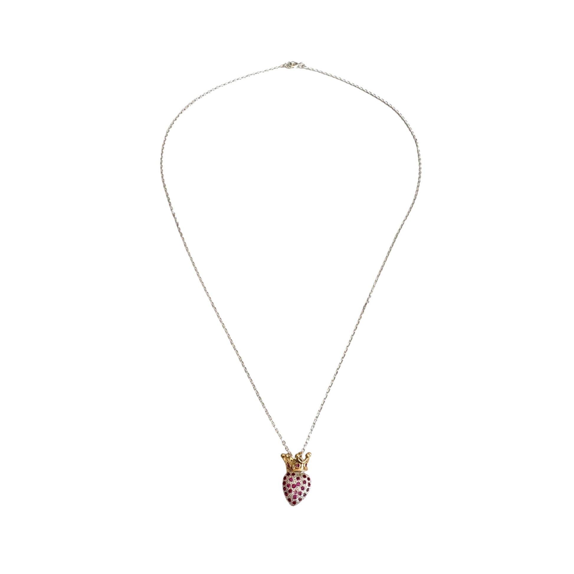 A long silver chain with a heart shaped pendant encrusted with red zirconias and topped with a gold crown.