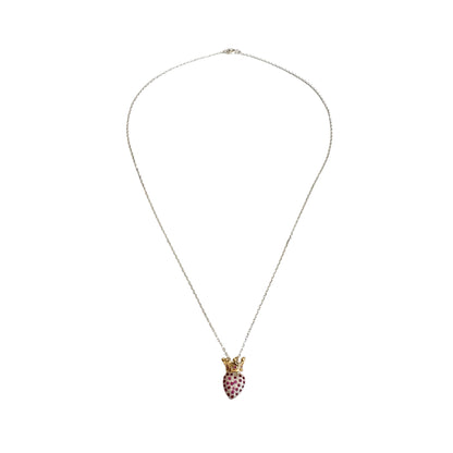 A long silver chain with a heart shaped pendant encrusted with red zirconias and topped with a gold crown.