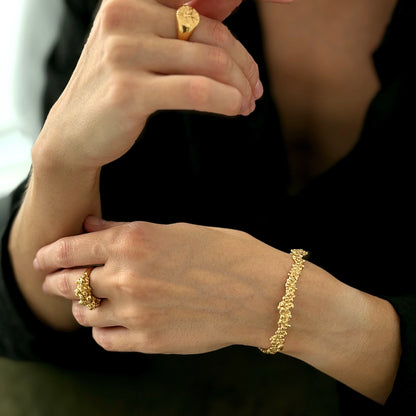 woman wearing golden rings and golden bracelet with organic texture