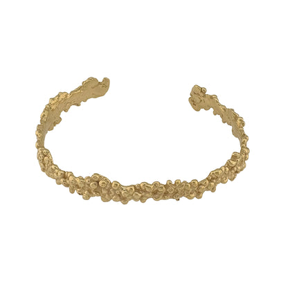 Golden bracelet with textured design on a white background