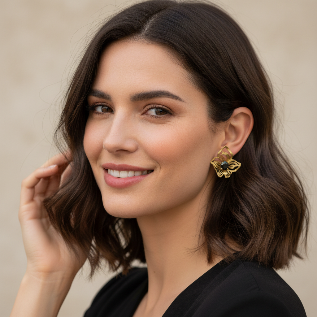 Woman wearing gold earrings with a neutral background
