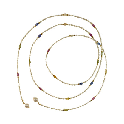 Long pearl necklace with multicolor gemstones and golden separators on a white background