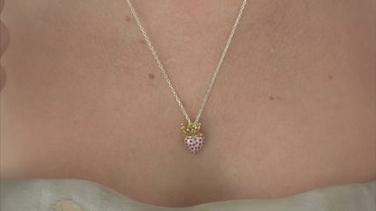 Silver chain with a heart shaped pendant encrusted with red zirconias and golden crown