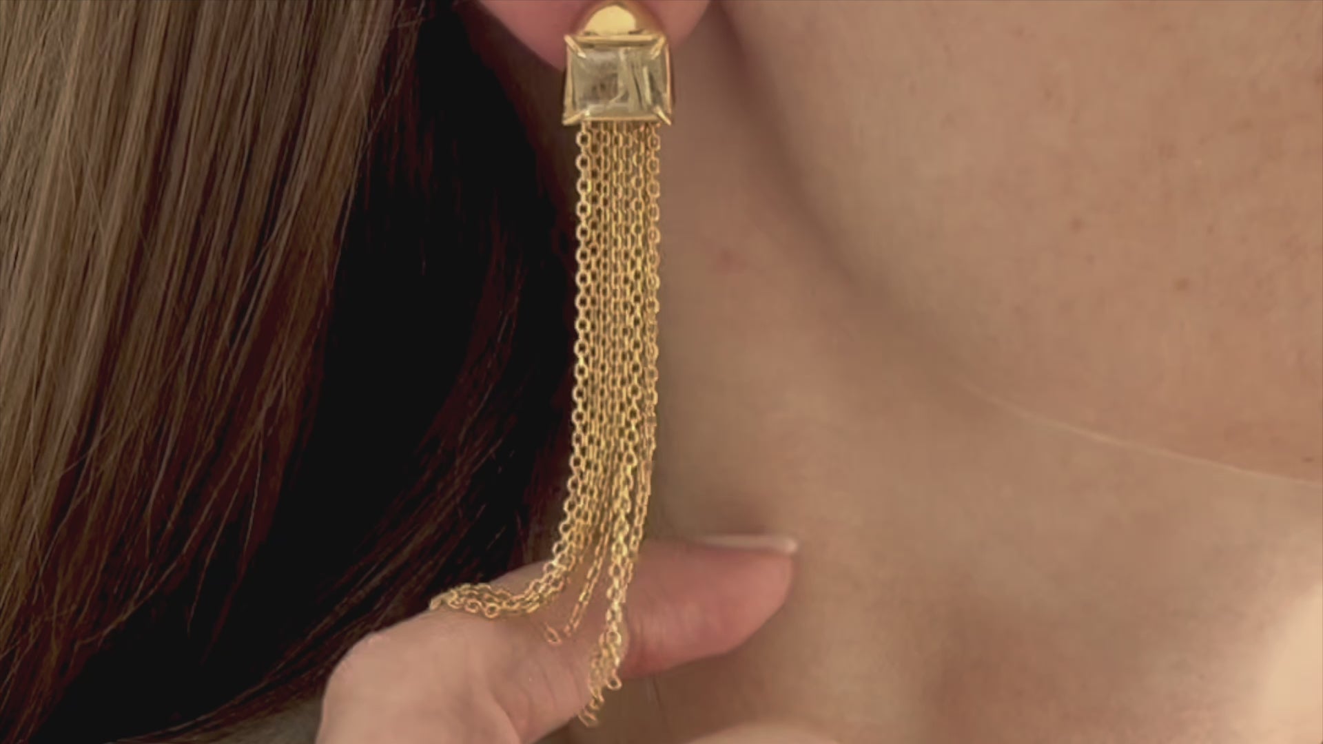 Female model playing with tassel golden chains earring