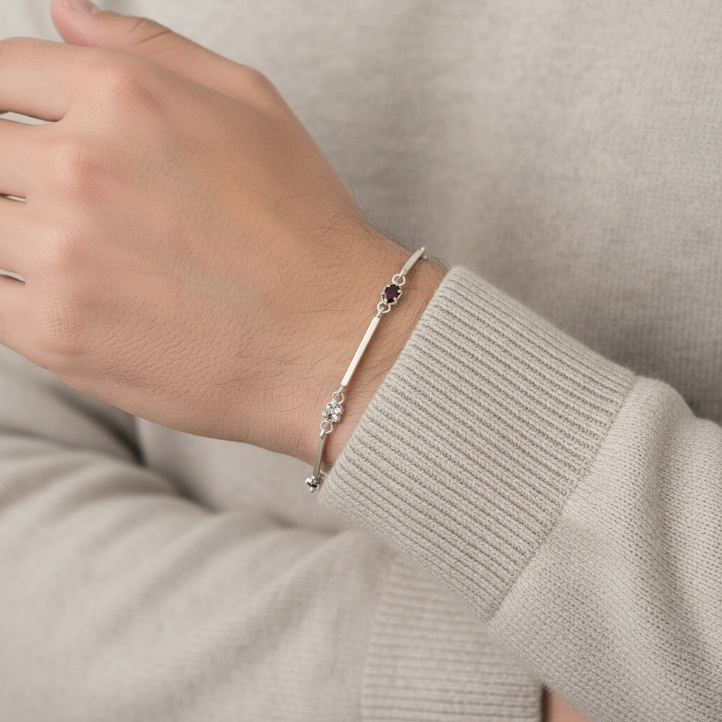male hand wearing a silver bracelet with stones dressed with a casual elegant sweater
